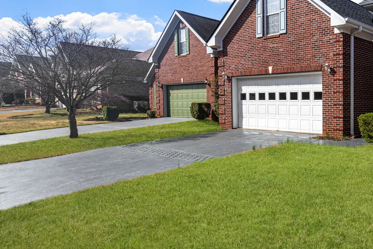 Brick home with a dark blacktop driveway leading to the garage