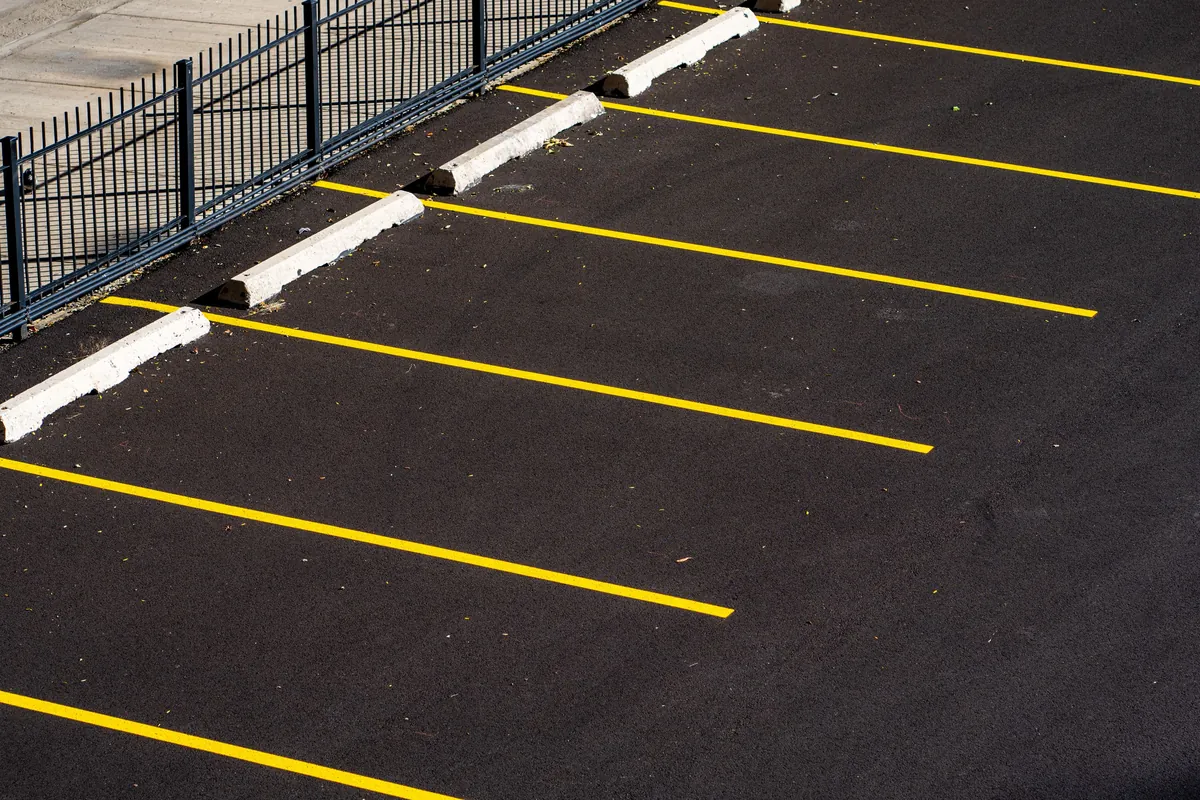 Freshly sealed parking lot with crisp yellow stall striping